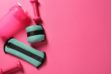 Photo of Turquoise weighting agents, dumbbells and shaker on pink background, flat lay. Space for text