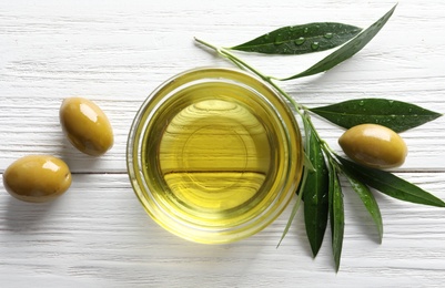 Flat lay composition with fresh olive oil on wooden background