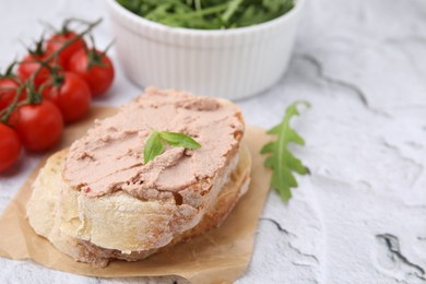 Delicious liverwurst sandwich with basil on white textured table, closeup. Space for text