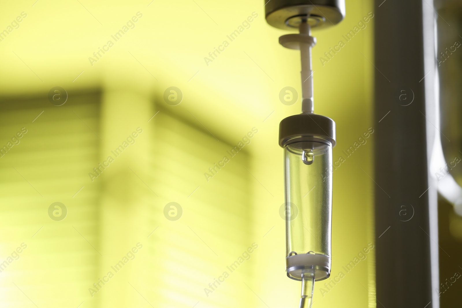 Photo of IV drip against blurred yellow background, space for text