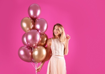 Young woman with air balloons on color background