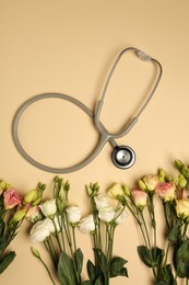 Photo of Stethoscope and flowers on dark beige background, flat lay. Happy Doctor's Day