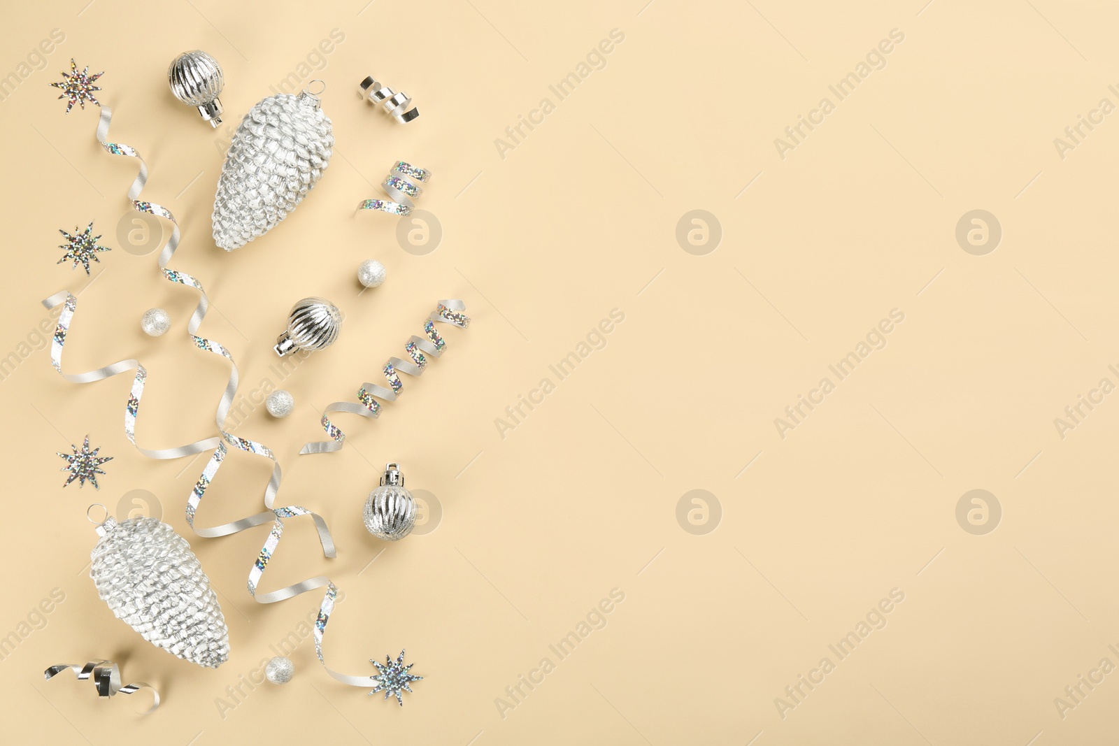 Photo of Flat lay composition with serpentine streamers and Christmas decor on beige background. Space for text