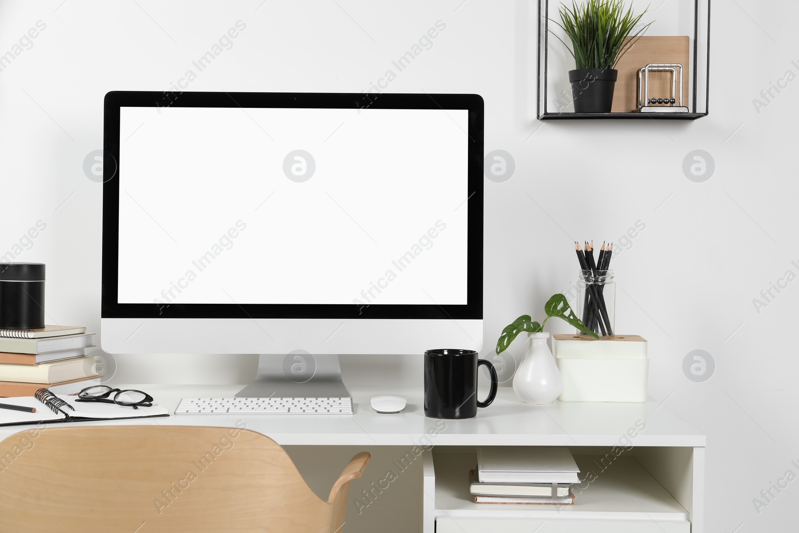 Photo of Cozy workspace with computer and stationery on wooden desk at home