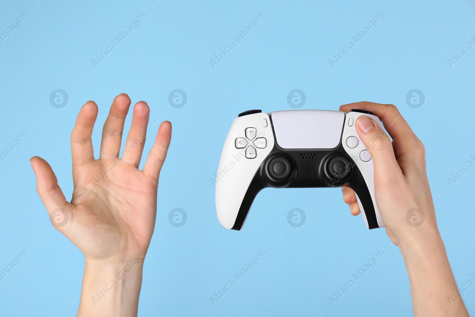 Photo of Woman with game controller on light blue background, closeup