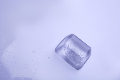 Photo of Ice cube on color background. Space for text