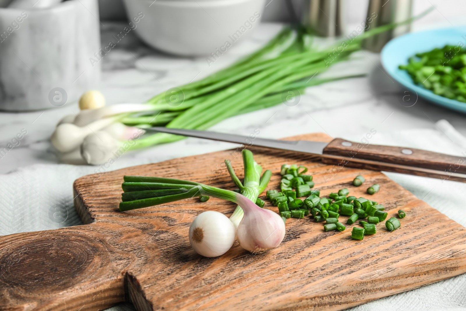 Photo of Fresh green onion on wooden board, closeup