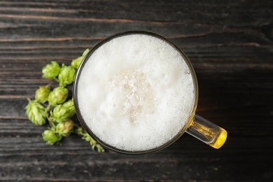 Photo of Flat lay composition with tasty beer and fresh green hops on wooden background