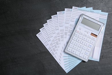 Photo of Calculator and documents on black stone table, top view. Tax accounting