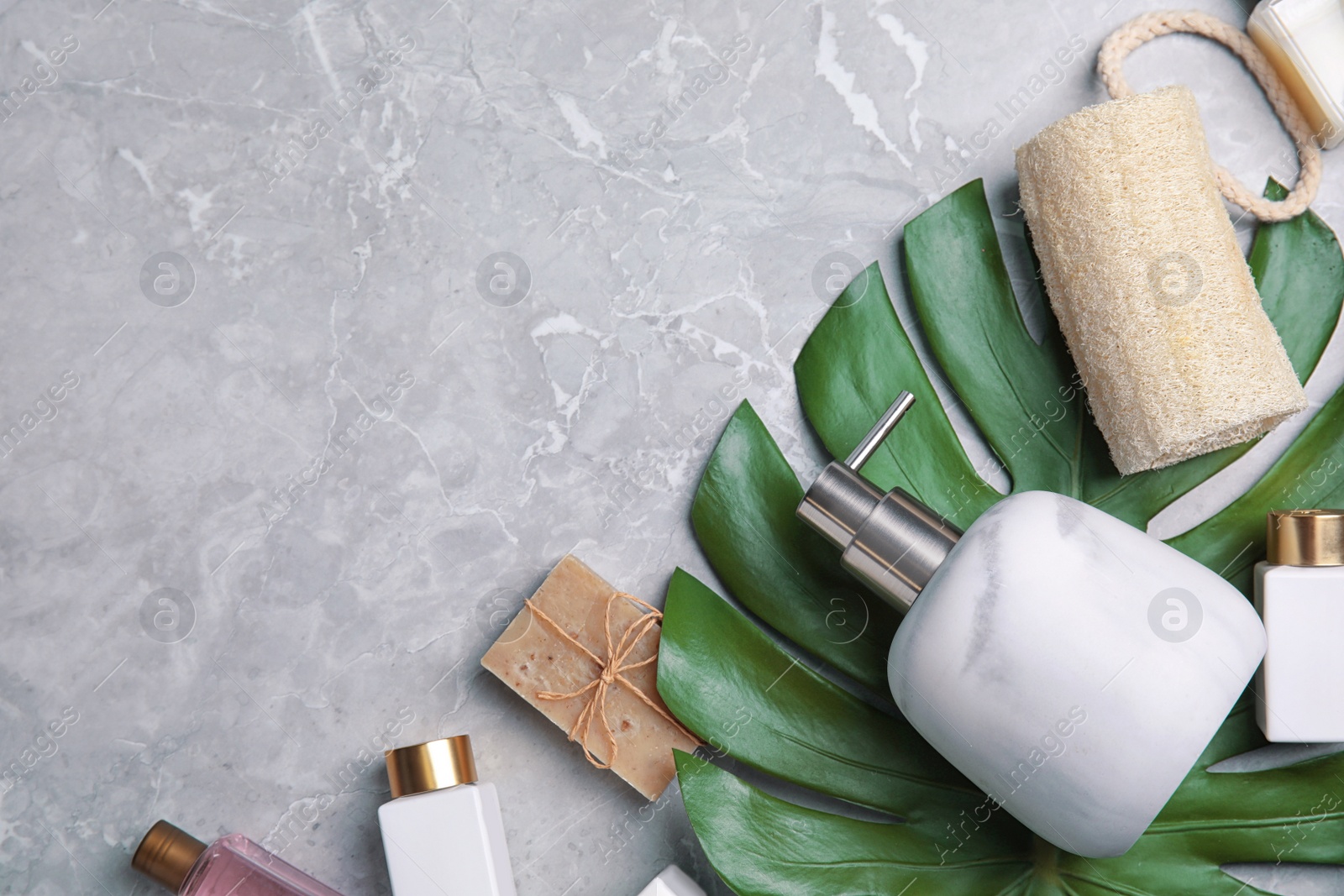 Photo of Flat lay composition with soap dispenser on grey marble background. Space for text