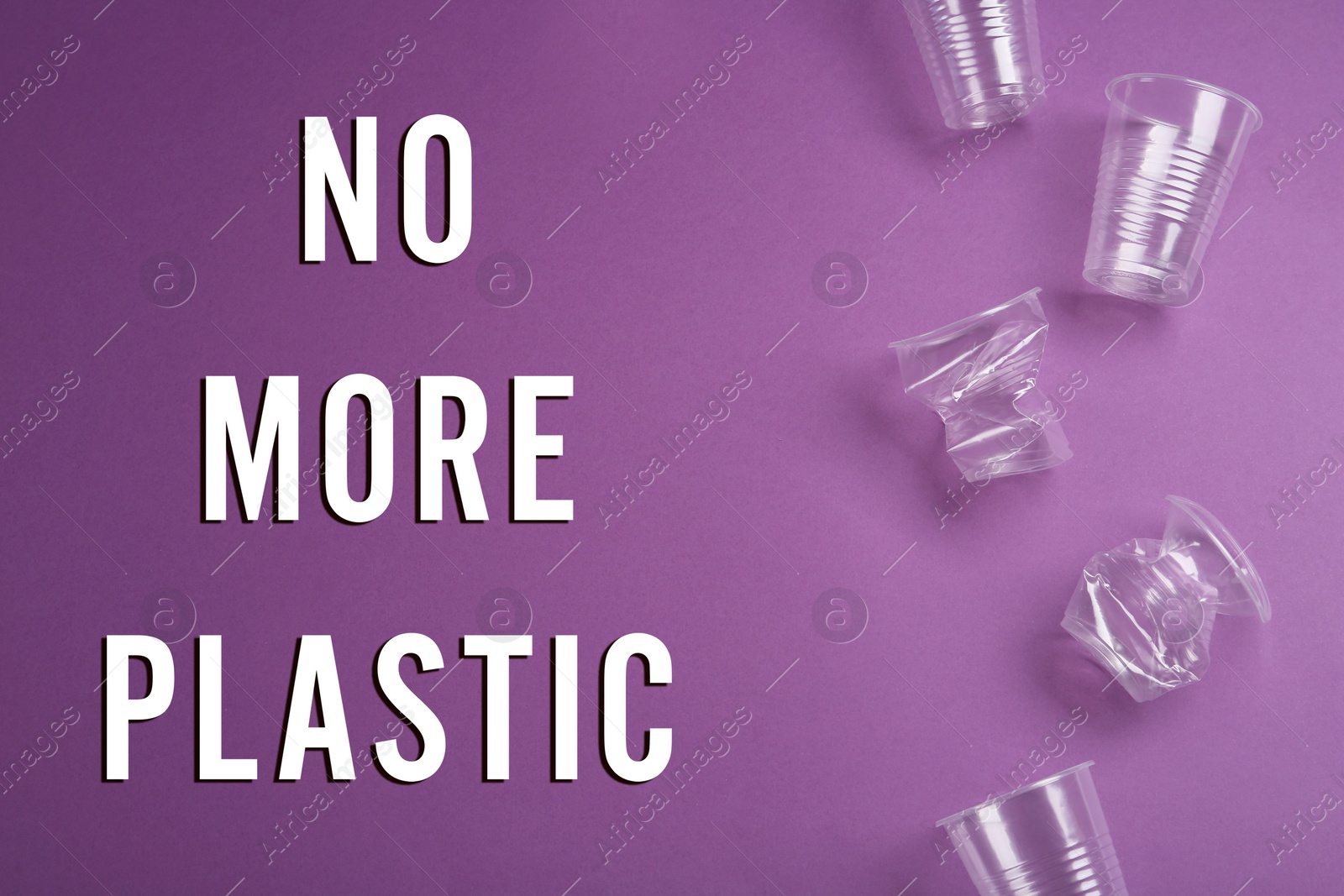 Image of Text NO MORE PLASTIC and different disposable cups on violet background, flat lay