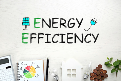 Image of Energy efficiency concept. Flat lay composition with chart and house figure on white wooden background