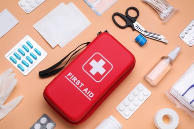 Photo of Flat lay composition with first aid kit on pale coral background