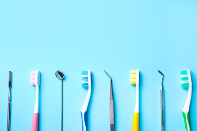 Photo of Different toothbrushes and dental tools on light blue background, flat lay. Space for text