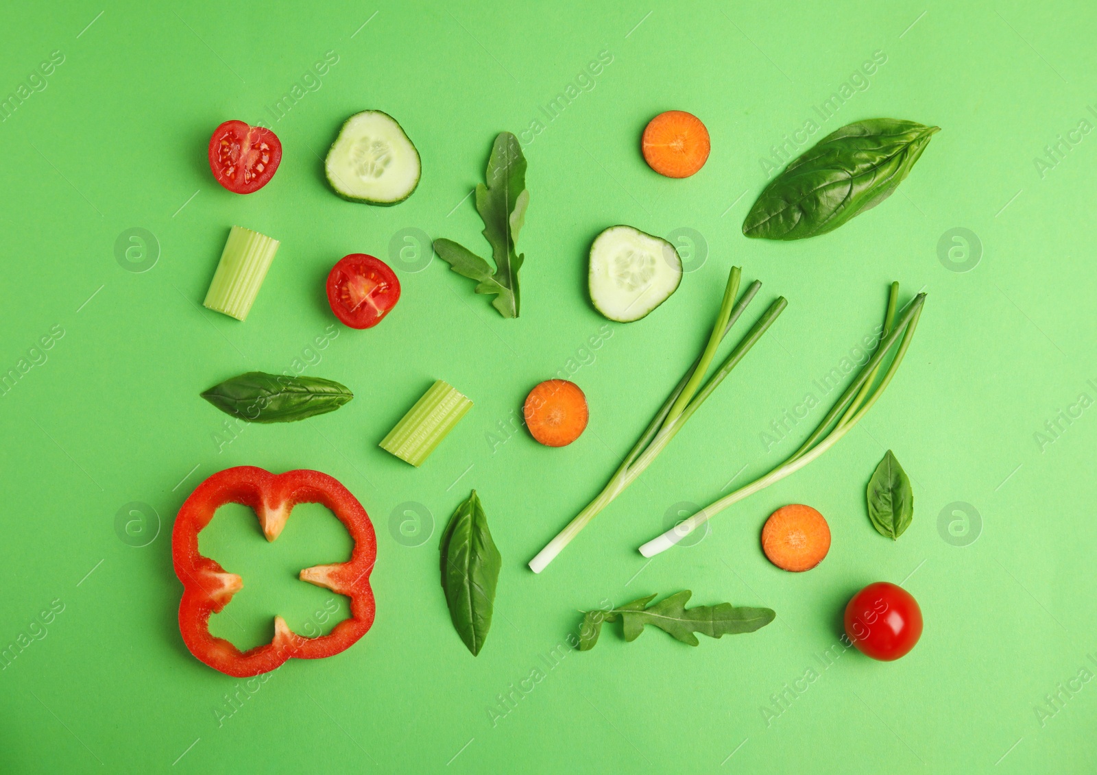 Photo of Flat lay composition with fresh ingredients for salad on green background