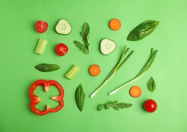 Photo of Flat lay composition with fresh ingredients for salad on green background