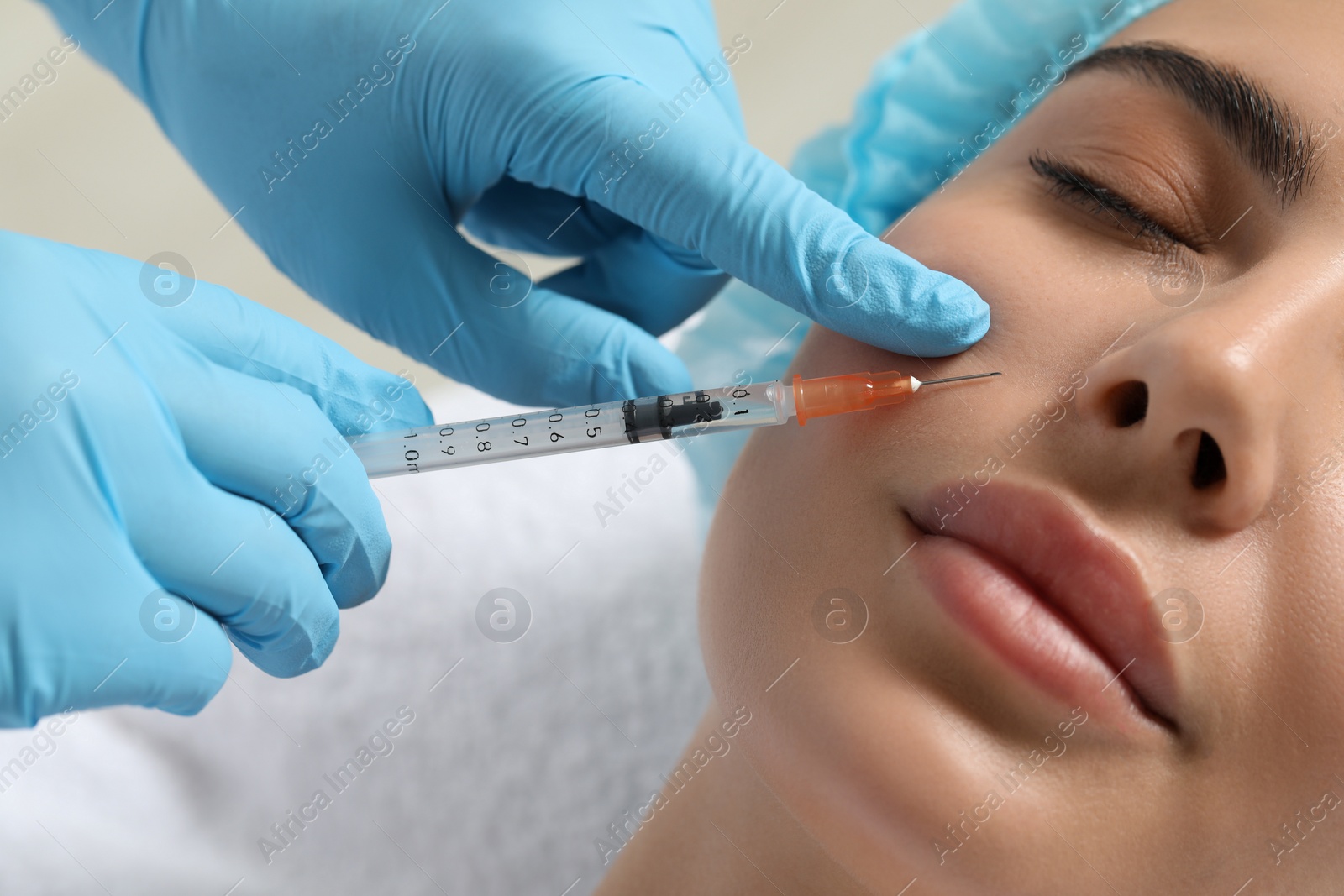 Photo of Doctor giving facial injection to young woman in clinic, closeup. Cosmetic surgery