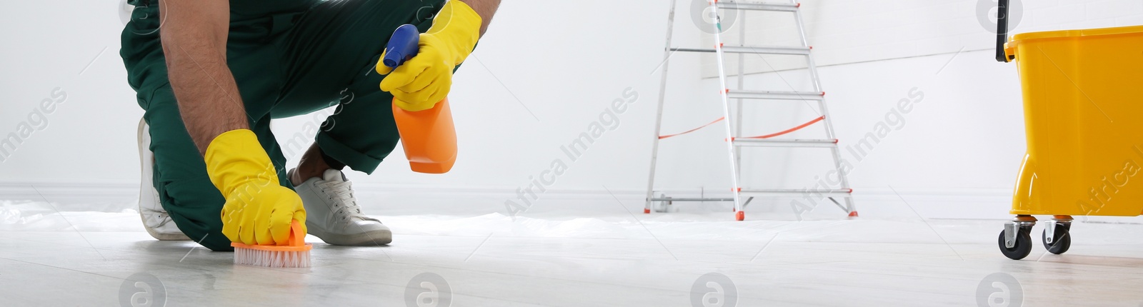 Image of Professional janitor cleaning floor with brush and detergent, closeup view. Banner design