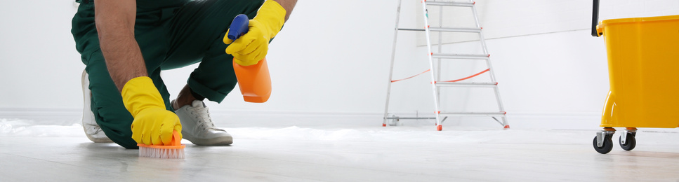 Professional janitor cleaning floor with brush and detergent, closeup view. Banner design