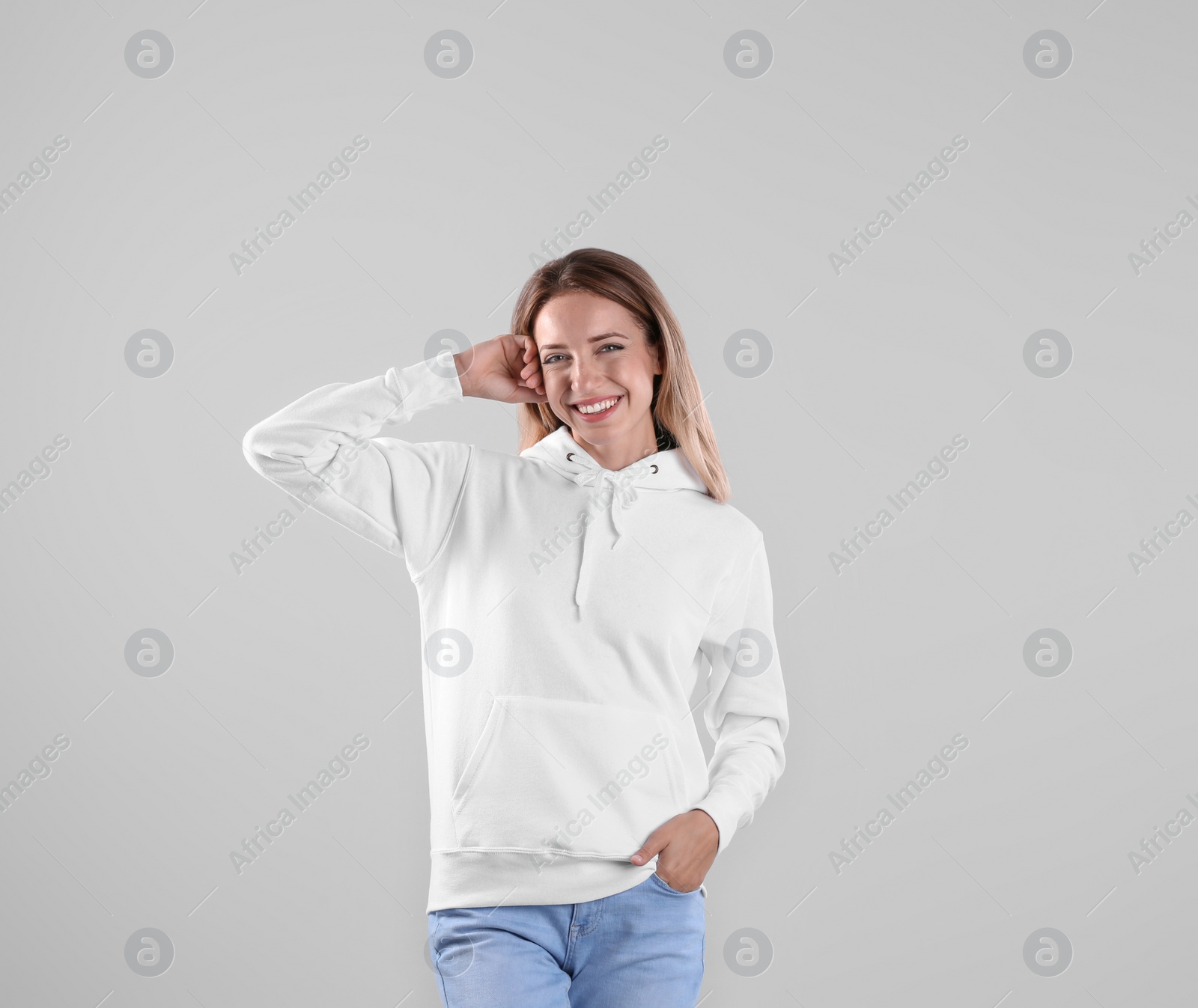 Photo of Portrait of woman in hoodie sweater on light background. Space for design