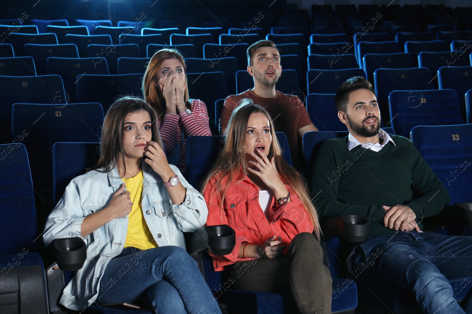 Photo of Young people watching movie in cinema theatre