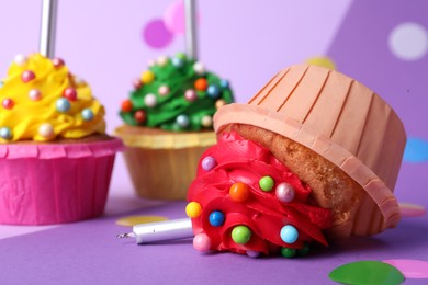 Photo of Dropped cupcake among good ones on color background, closeup. Troubles happen