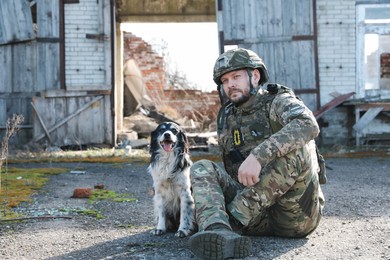 Photo of Ukrainian soldier with stray dog outdoors on sunny day