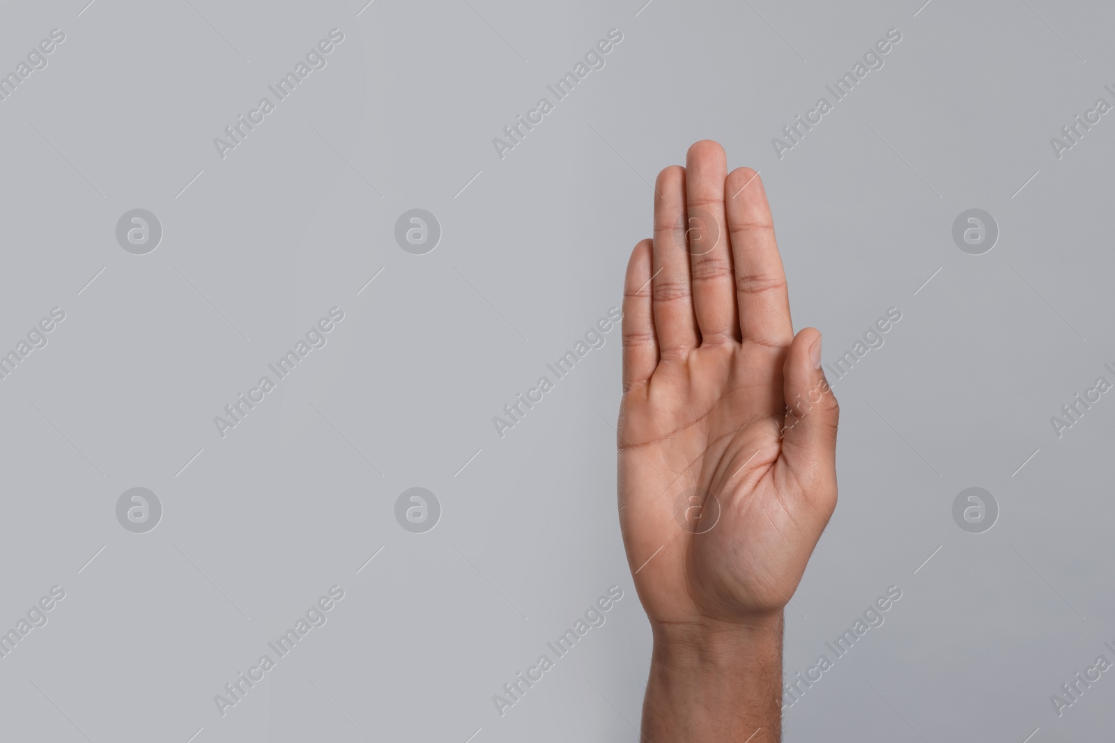 Photo of Man giving high five on grey background, closeup of hand. Space for text