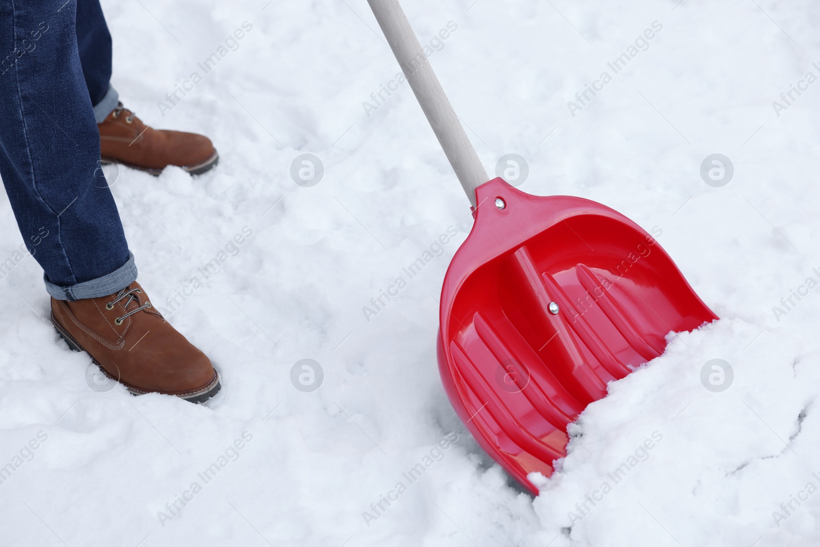 Photo of Man removing snow with shovel outdoors, closeup