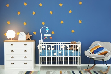Photo of Baby room interior with comfortable crib and rocking chair