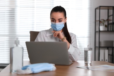 Photo of Female worker with mask in office. Protective measure during COVID-19 pandemic