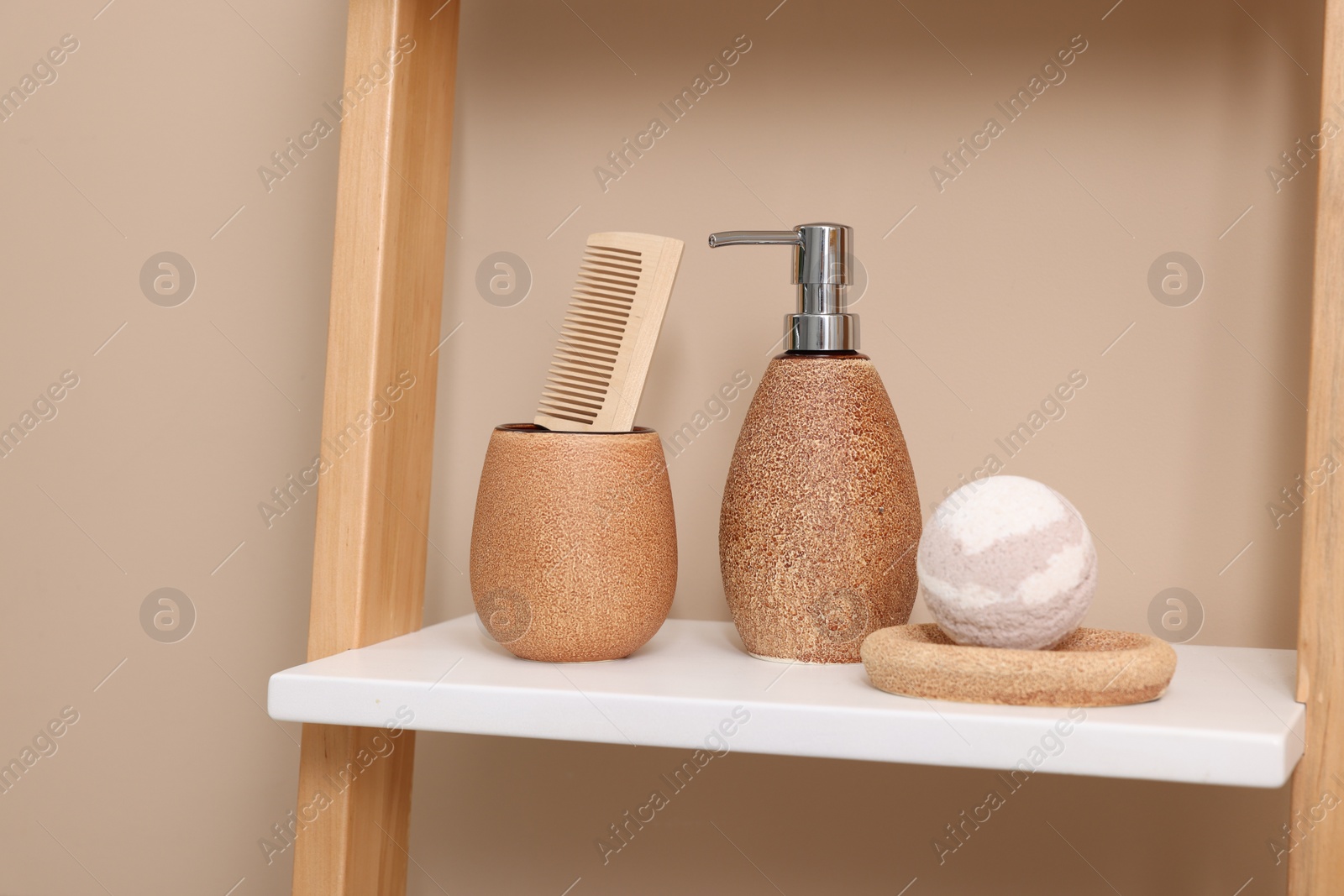 Photo of Different bath accessories and personal care products on shelving unit near beige wall