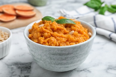 Bowl of tasty sweet potato puree on marble table