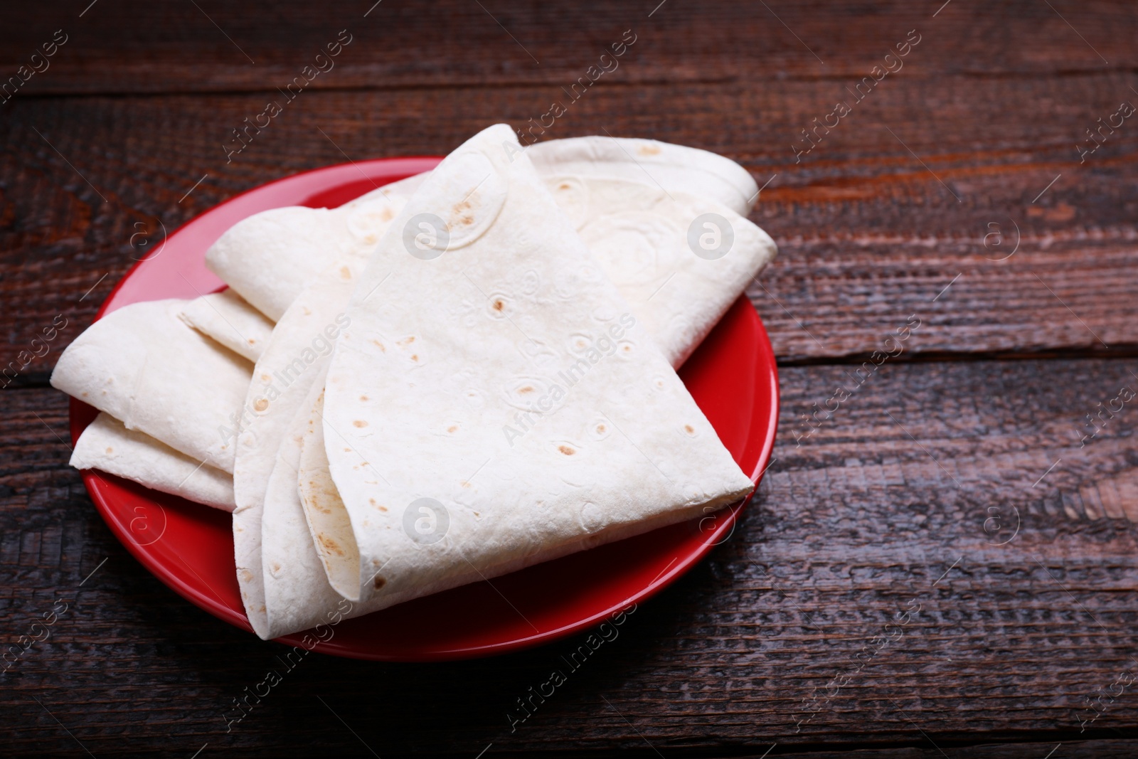 Photo of Delicious folded Armenian lavash on wooden table. Space for text