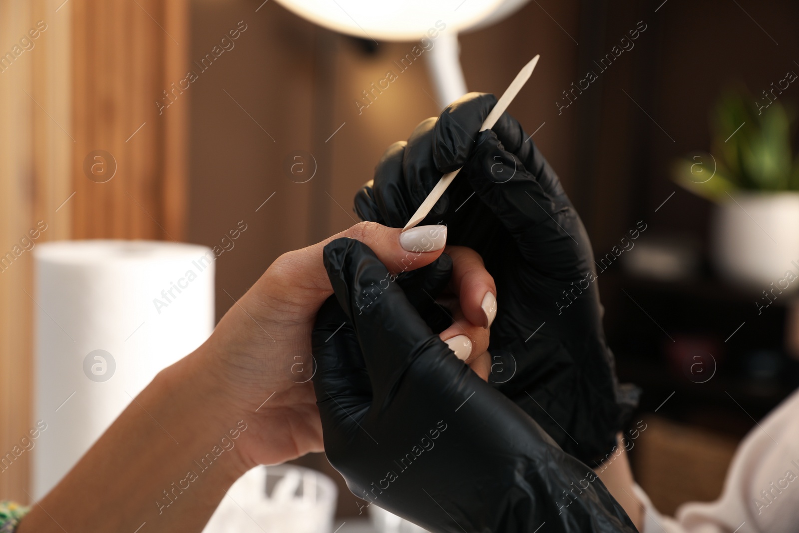 Photo of Professional manicurist working with client in salon, closeup. Beauty services during Coronavirus quarantine