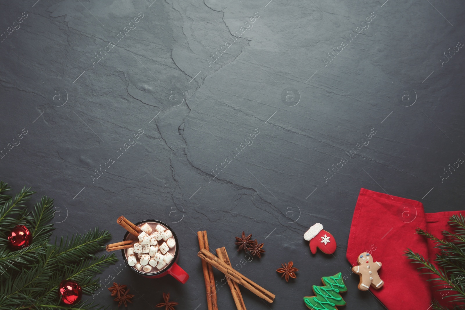 Photo of Delicious hot chocolate with marshmallows and Christmas decor on black table, flat lay. Space for text