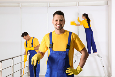 Photo of Team of professional janitors cleaning room after renovation