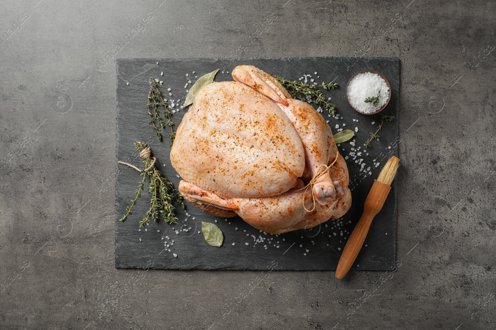 Photo of Slate plate with raw spiced turkey on grey background, top view