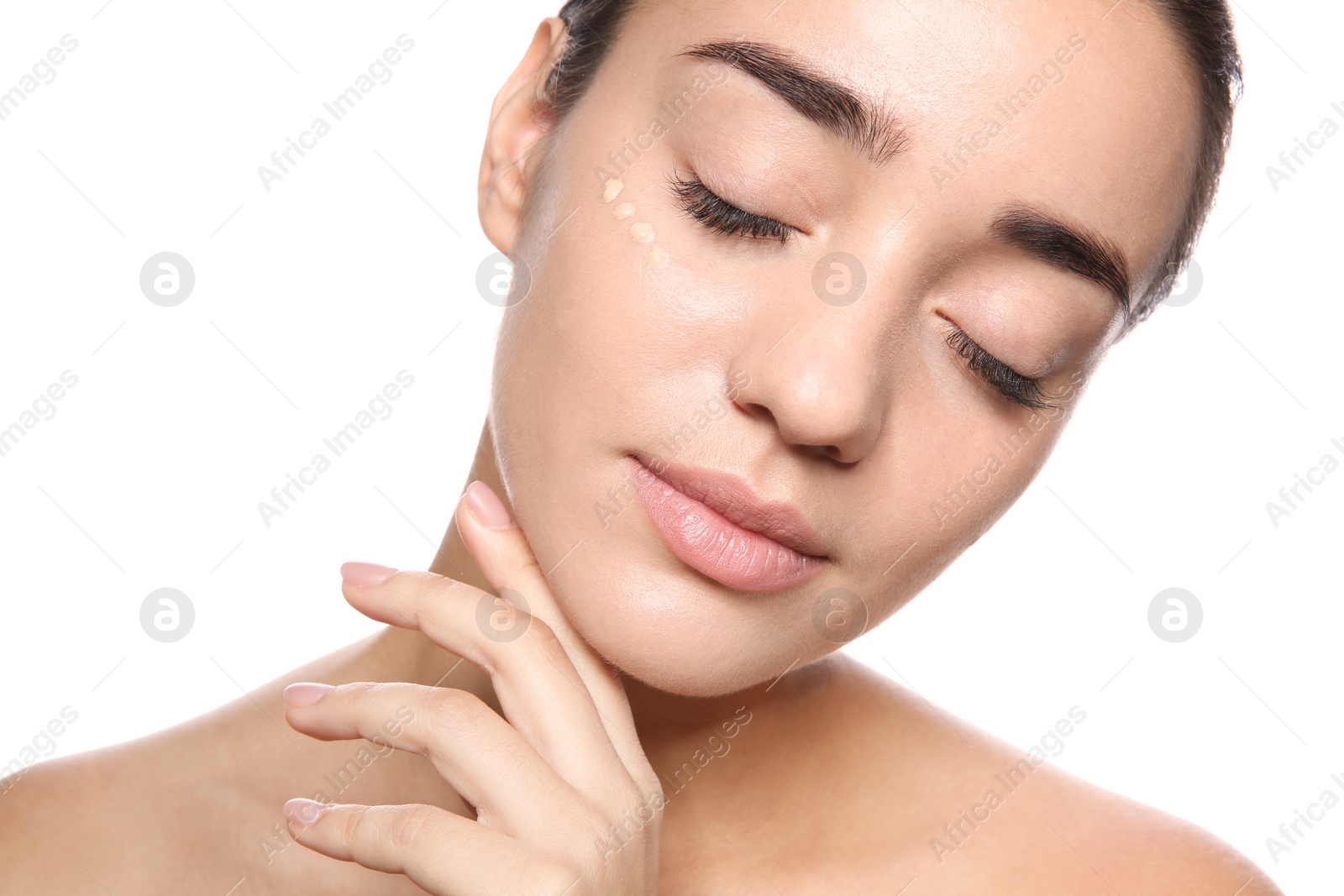 Photo of Portrait of young woman with liquid foundation on her face against white background