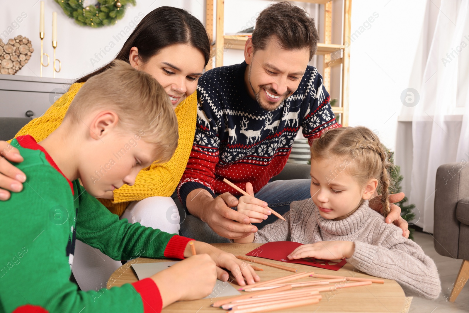 Photo of Cute children with their parents making beautiful Christmas greeting cards at home