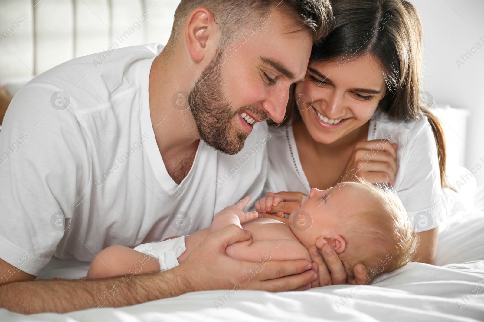 Photo of Happy couple with their newborn baby at home