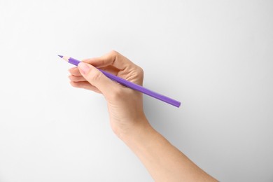 Woman with purple pencil on white background, closeup