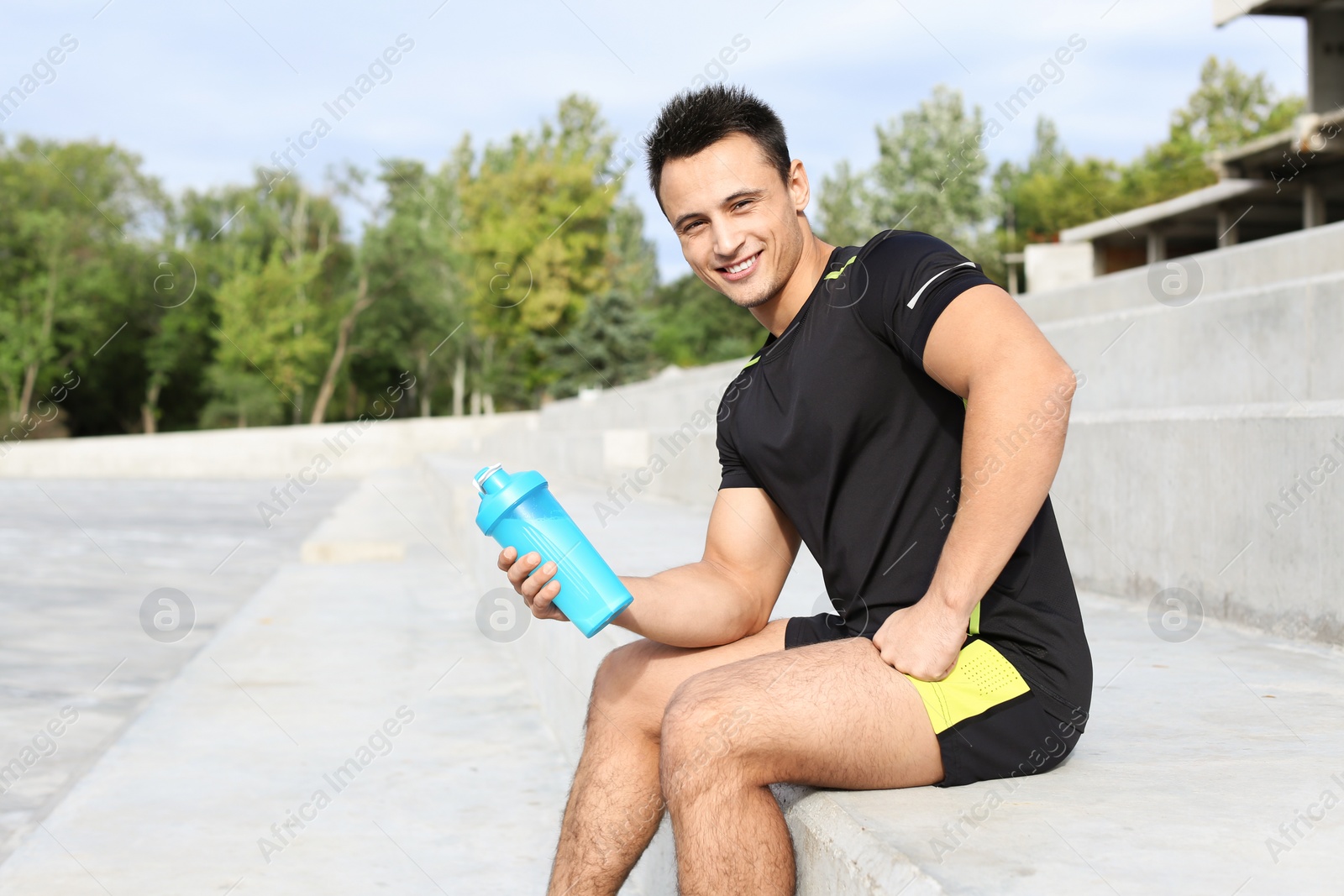 Photo of Man with bottle of protein shake on street