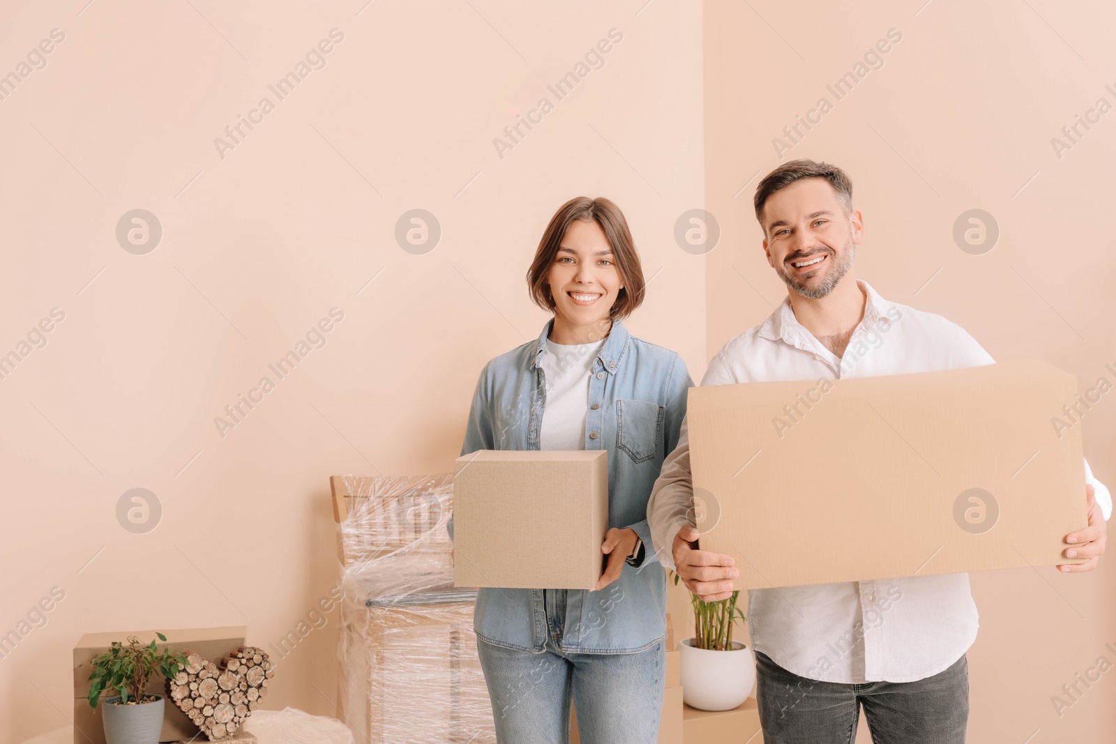 Photo of Happy couple with moving boxes in new apartment