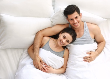 Lovely young couple resting in large bed, above view