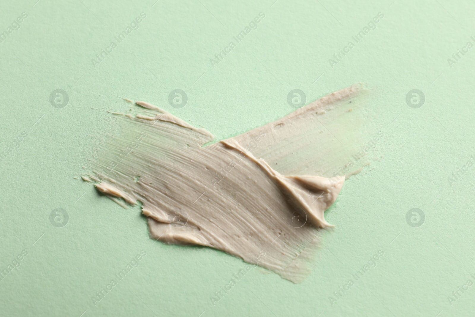 Photo of Sample of face mask on light green background, top view