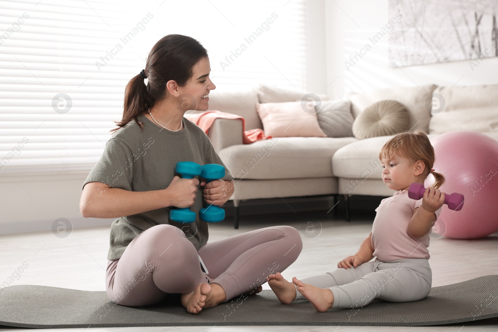 Photo of Mother doing exercise with her daughter at home