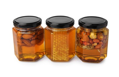 Jars with different nuts and honey on white background