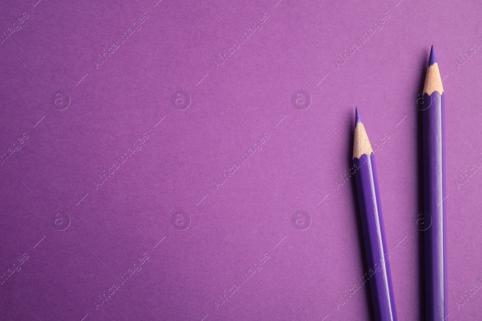 Photo of Flat lay composition with color pencils on purple background. Space for text