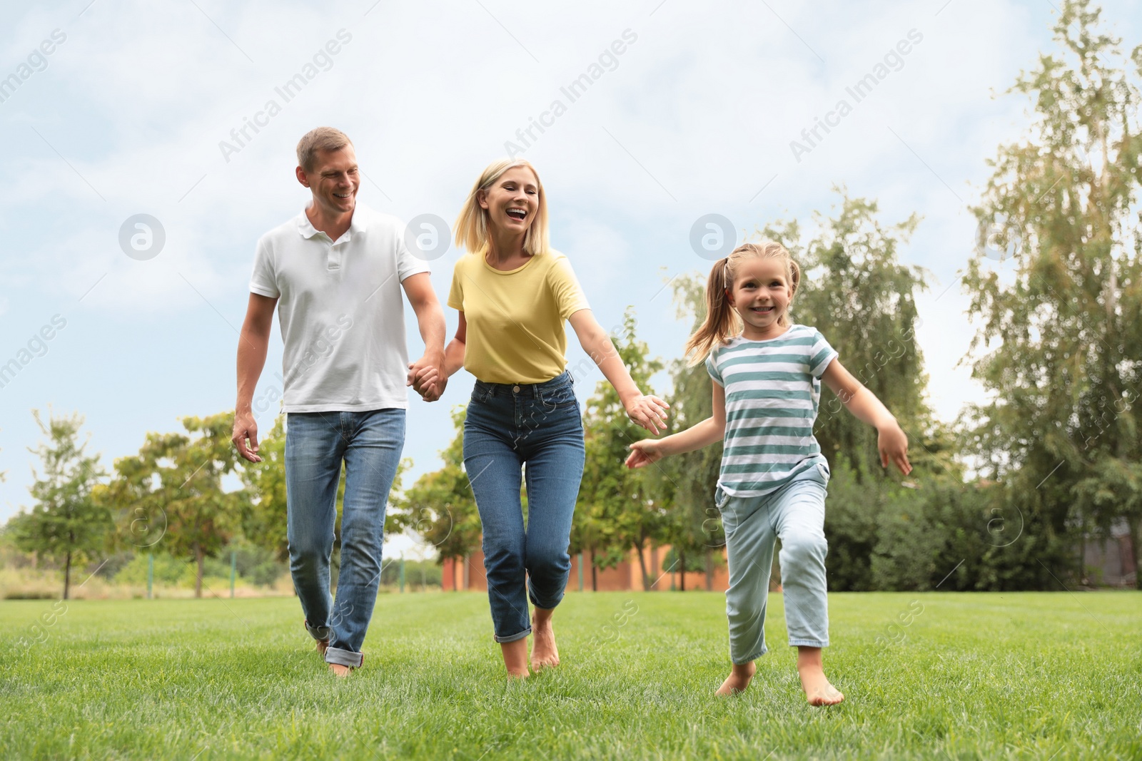 Photo of Happy family running in park on summer day